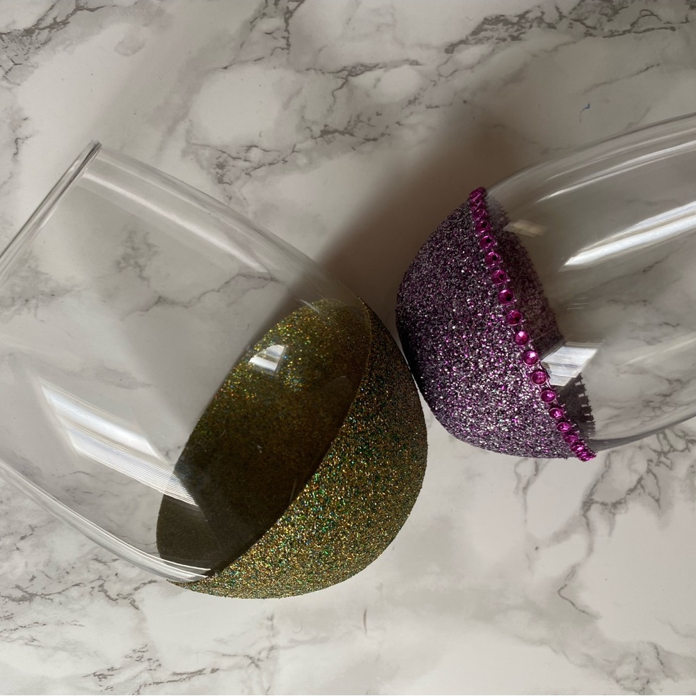Two different sized decorative stemless glasses .